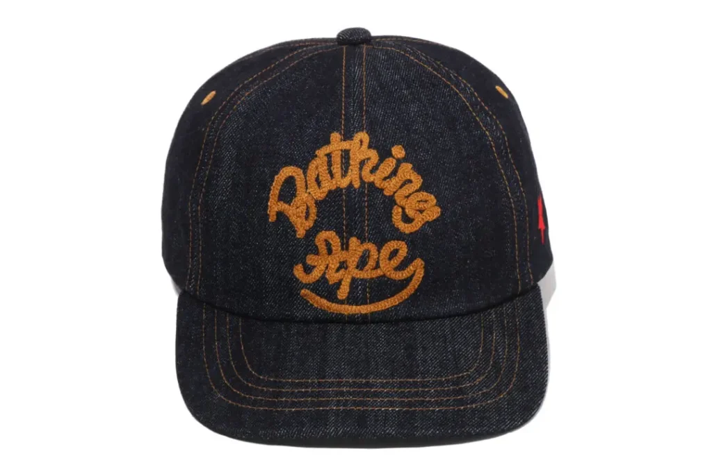 Dark denim A BATHING APE baseball cap with embroidered Bathing Ape script logo and contrast orange stitch