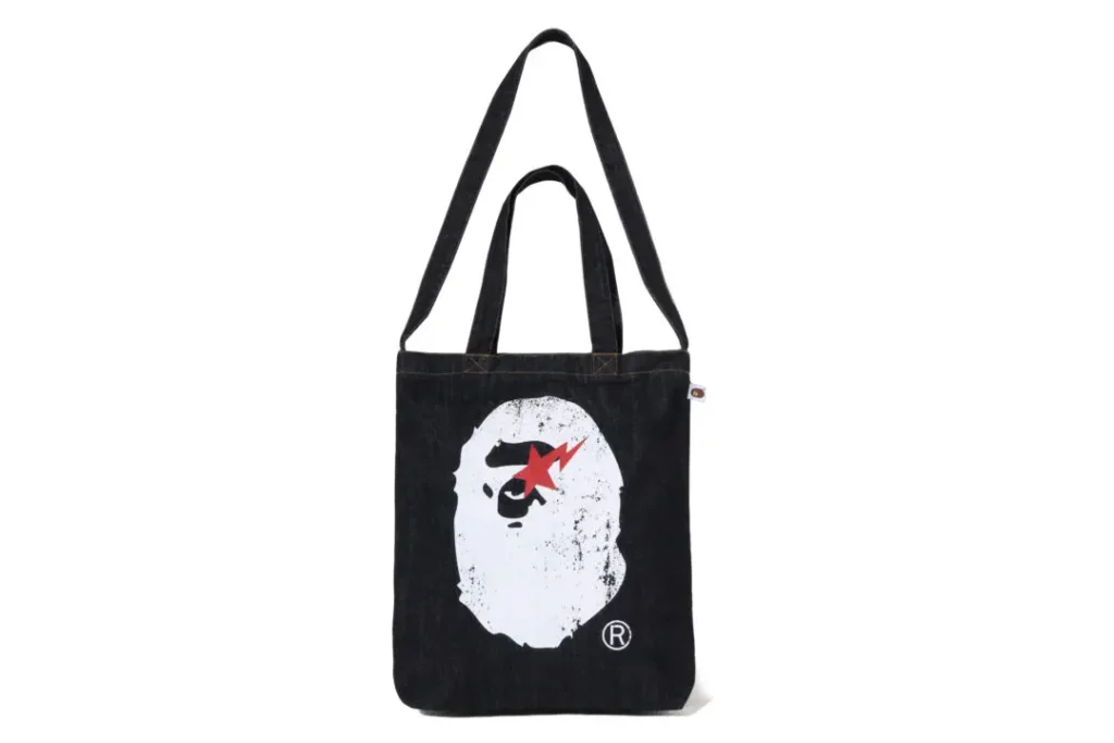 A BATHING APE denim tote bag featuring a large distressed ape-head graphic and durable shoulder strap