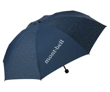 Navy blue Montbell compact umbrella featuring reflective geometric triangle-pattern panels and a contrasting solid section with the Montbell logo. Shown open against a light gray background