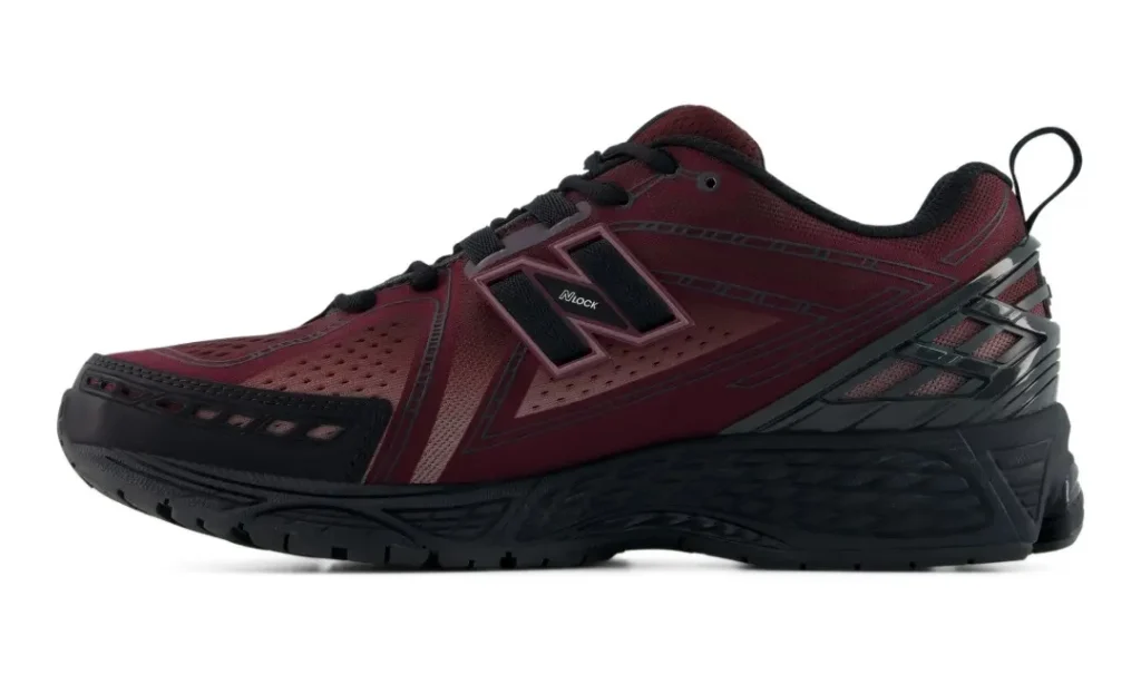 Medial side view of the New Balance 1906E featuring tonal burgundy overlays, perforated mesh sections, a rugged black midsole, and technical cushioning component
