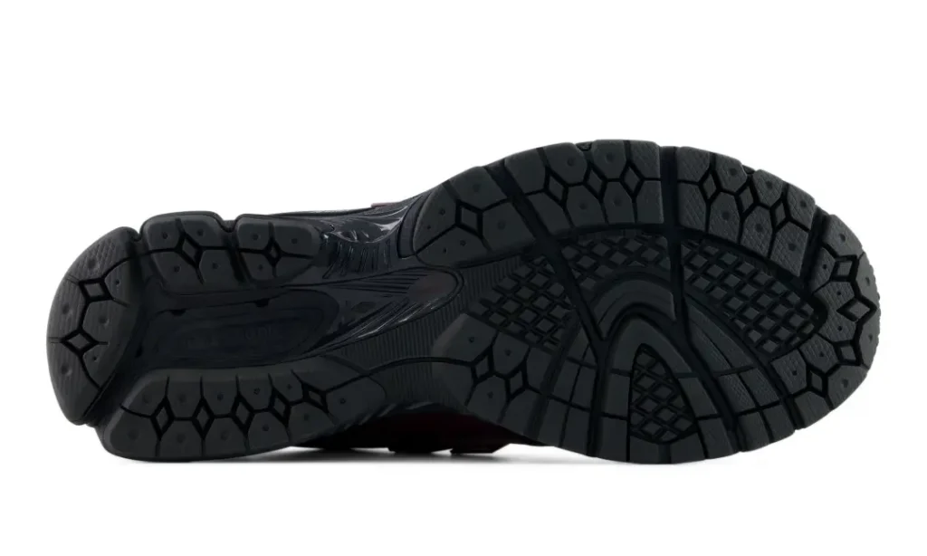 Outsole detail of the New Balance 1906E displaying an all-black traction pattern with segmented tread zones designed for stability, grip, and everyday comfort