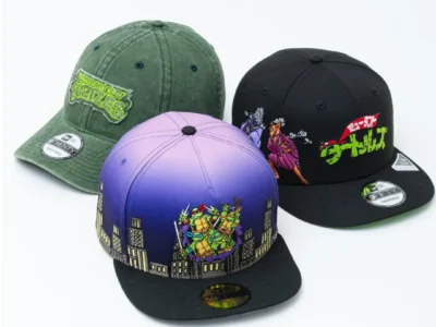 Three Teenage Mutant Ninja Turtles x New Era caps displayed against a clean white background. The collection includes a washed olive-green 9TWENTY cap with a distressed TMNT logo patch, a black 9FIFTY snapback featuring Japanese-inspired Turtle artwork and bold neon-green lettering, and a purple-to-blue gradient fitted cap embroidered with the four turtles emerging above a stylized city skyline