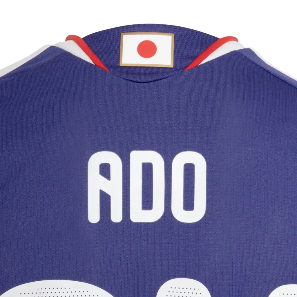 Rear collar detail of the Ado Japan football jersey showing the ADO name print and Japanese flag-inspired neck label