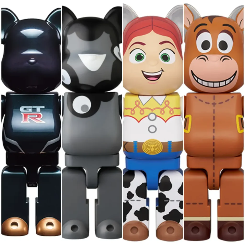 A composite image showcasing four collectible Bearbrick-style designer figures arranged side by side against a clean white background. From left to right: a glossy black figure inspired by the Nissan GT-R, featuring reflective surfaces, a GT-R logo on the torso, and bronze-toned foot accents; a minimalist black-and-gray figure decorated with abstract monochrome graphic shapes; a colorful figure modeled after Jessie from Toy Story, complete with red braided hair, a yellow western shirt, blue pants, and cow-print chaps; and a brown figure inspired by Bullseye, the horse from Toy Story, featuring a cheerful cartoon face, stitched detailing, and western saddle-inspired graphics. The lineup highlights a mix of automotive, contemporary art, and animated character influences within the iconic Bearbrick sil