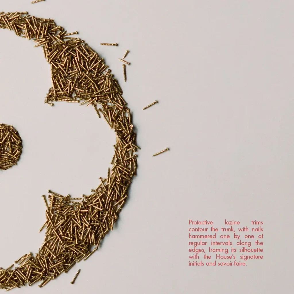 Detailed view of Louis Vuitton’s lozine trimming process, where brass nails reinforce and decorate the trunk’s edge