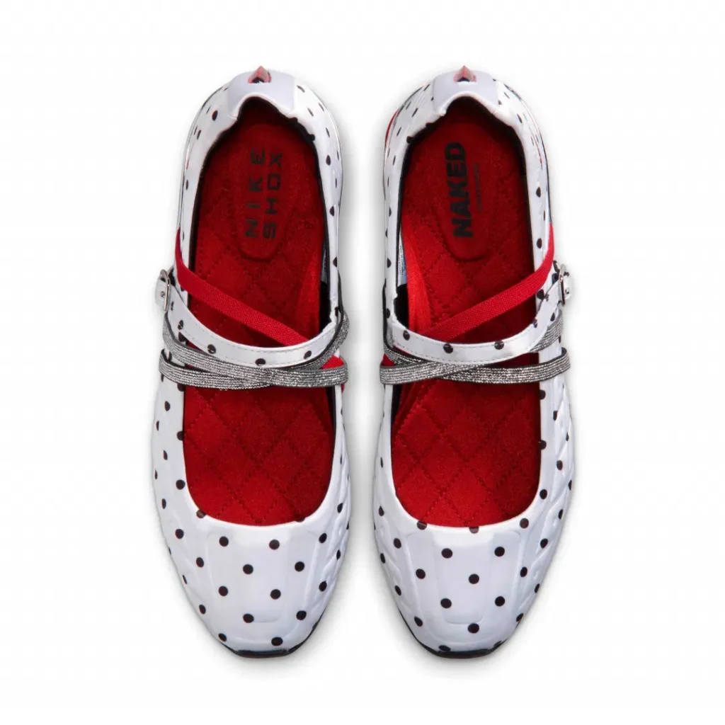 Overhead view of the Nike Shox Mary Jane pair highlighting vibrant red quilted insoles, white polka-dot uppers, silver crossover straps, and red elastic bands securing the foot across the instep