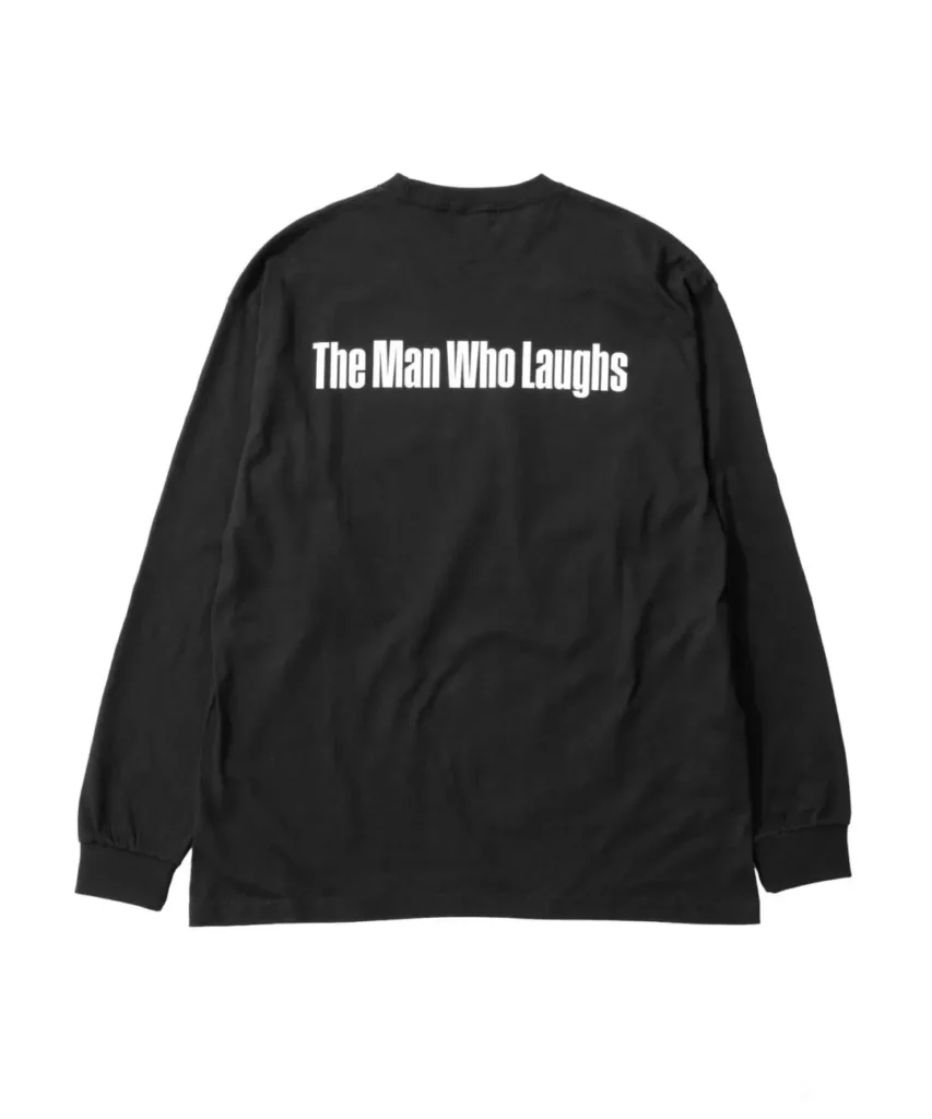Back view of the black long-sleeve shirt displaying the phrase "The Man Who Laughs" in large white lettering across the upper back. The minimalist design contrasts against the black fabric, completing the tribute-inspired apparel collection
