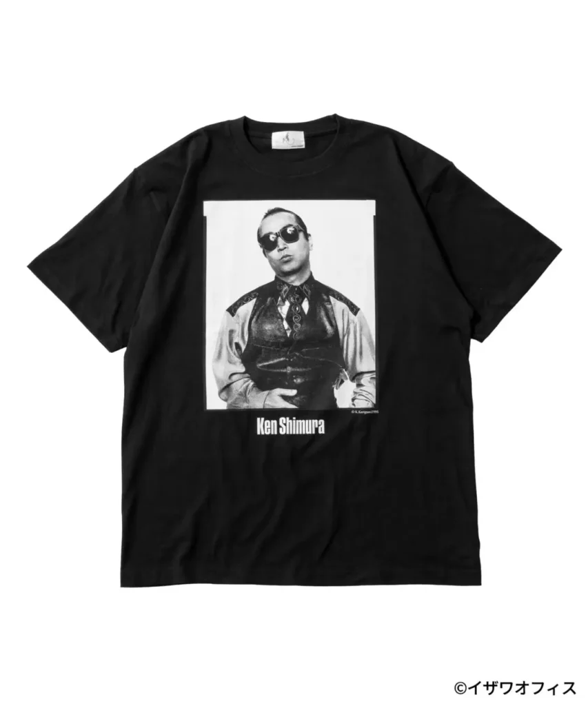 Black short-sleeve T-shirt featuring a large monochrome portrait of Ken Shimura in sunglasses and a vest. His name appears beneath the photograph, creating a bold front graphic that stands out against the solid black cotton fabric