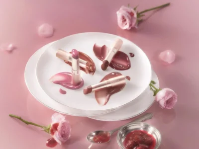 OPERA 26 Autumn Cosmetics Rose Jam and Sugar Glamer lip tints in brown and bordeaux shades displayed on white plate with rose petals and jam, pink background