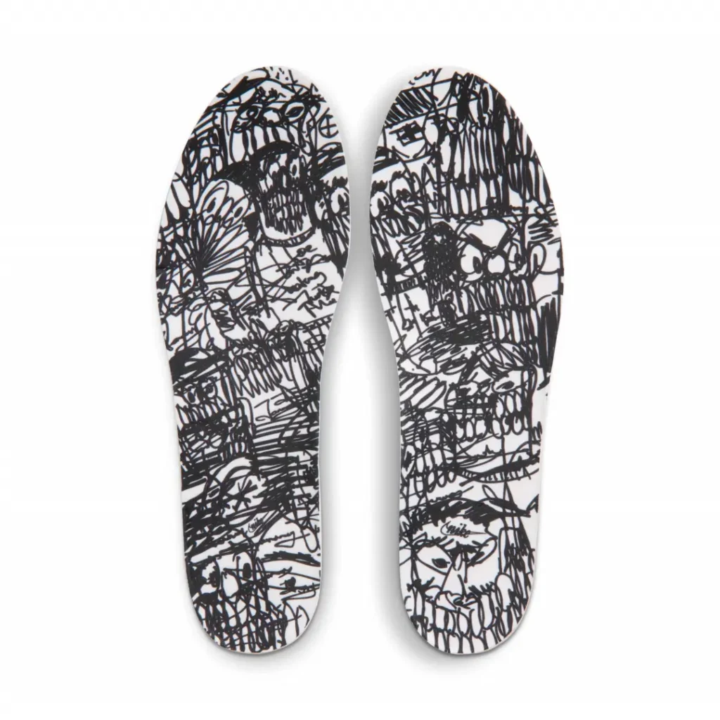 Custom insole artwork covered in expressive black marker-style sketches, faces, and abstract illustration