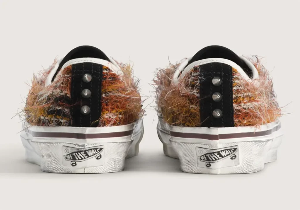 Close-up of the burgundy colorway. Rich wine-colored suede wraps the forefoot, paired with layered multicolored fibers, white laces, silver studs, and jewel-like accents that create a handcrafted, customized appearance