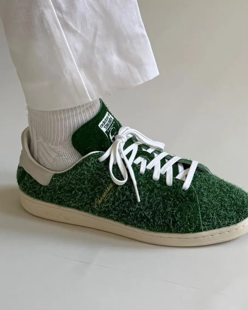 side profile close-up of the shoe showing a cream suede heel tab embroidered with a green rose logo and "chavarria" branding. The shaggy green heel panel, stitched leather overlays, and vintage off-white sole are shown in detail