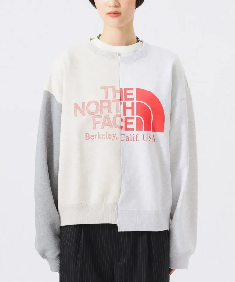 The North Face split-panel crewneck sweatshirt with oversized fit, color-block construction, and oversized logo graphic in soft grey tone