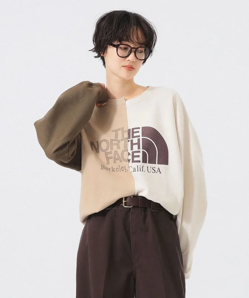 Model wearing beige and cream The North Face color-block sweatshirt featuring oversized logo graphic and relaxed contemporary fit
