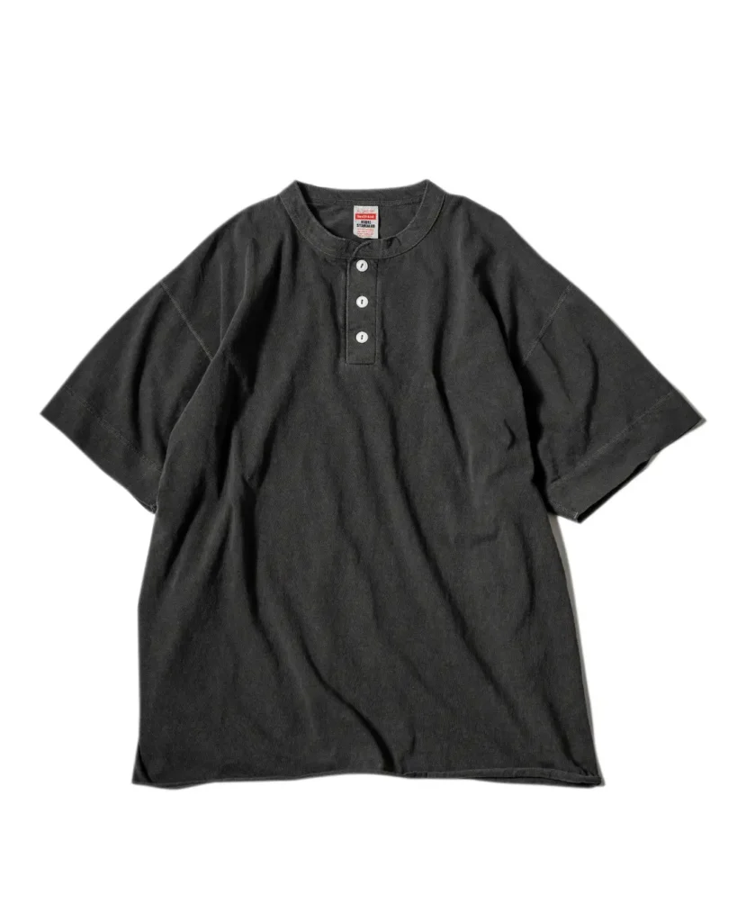 Dark charcoal Healthknit HIGH! STANDARD short-sleeve Henley T-shirt with a three-button placket displayed on a white background. The heavyweight cotton tee features a relaxed fit, garment-dyed finish, and vintage-inspired casual design