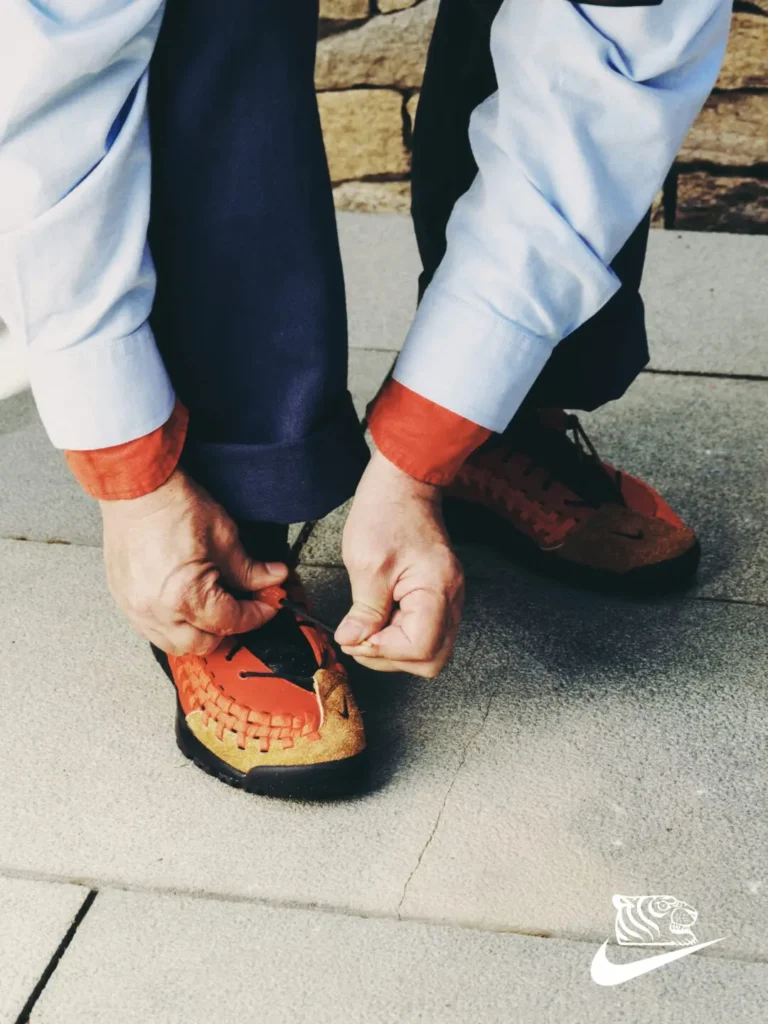 SOULGOODS x Nike Homescape Woven SP Chile Red on foot in casual blue shirt and dark pants setting, featuring tiger logo and 'Home is Where the Soul Is' campaign tagline