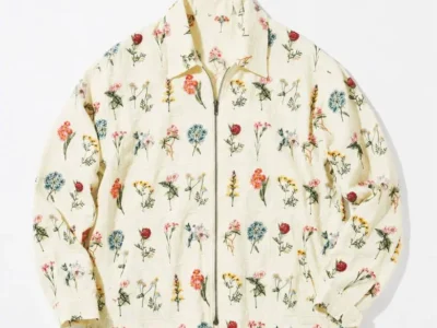 A rear view reveals the all-over floral embroidery extending seamlessly across the back panel. The understated cream base allows the botanical details to take center stage, while the clean silhouette and lightly structured collar maintain a polished, versatile appearance