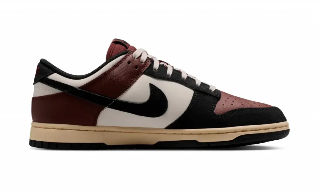 Medial side profile of the burgundy, sail, and black Nike Dunk Low showcasing contrasting sail leather panels, black suede overlays, burgundy heel and eyestays, and cream mid