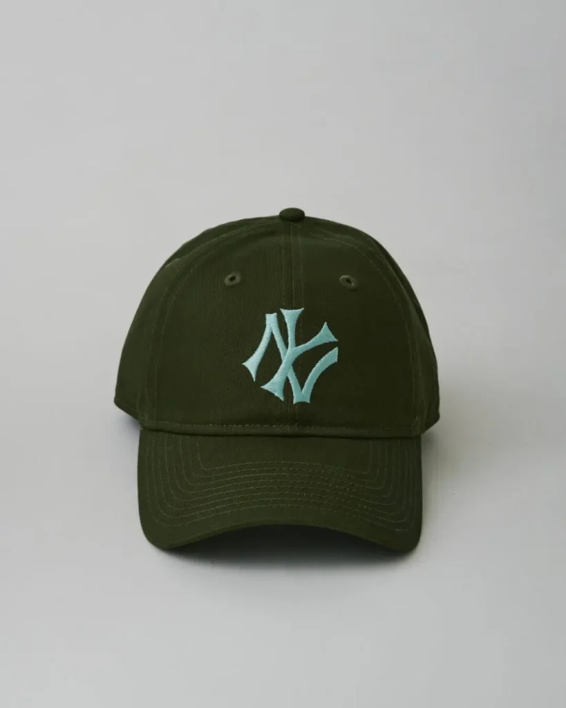 Front view of an olive-green New York Yankees cap featuring a mint-colored embroidered NY logo, six-panel construction, and curved visor