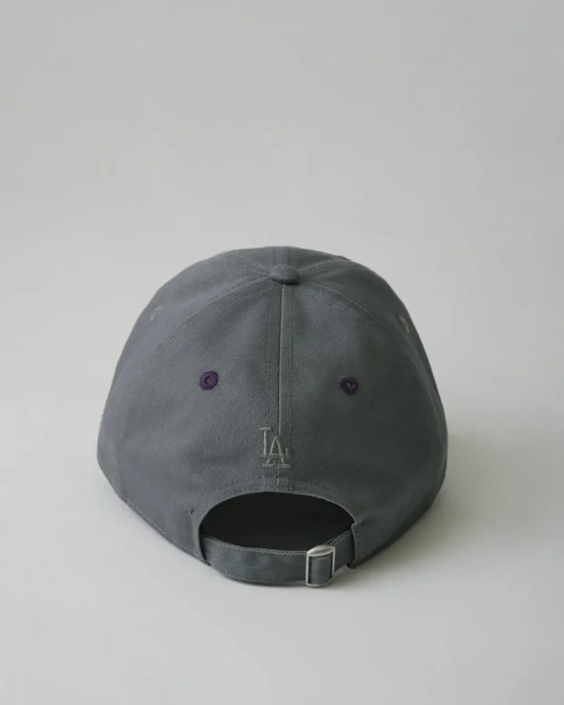 Rear view of the turquoise Yankees cap featuring pink eyelet accents, white rear logo embroidery, and an adjustable buckle closure