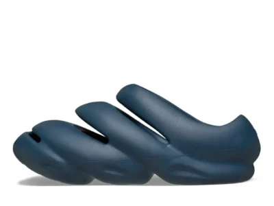 Side profile of the Crocs THE ROY "Nightfall" slip-on showcasing its sculptural navy foam construction, segmented upper design, and large horizontal ventilation channels inspired by modern architectural forms