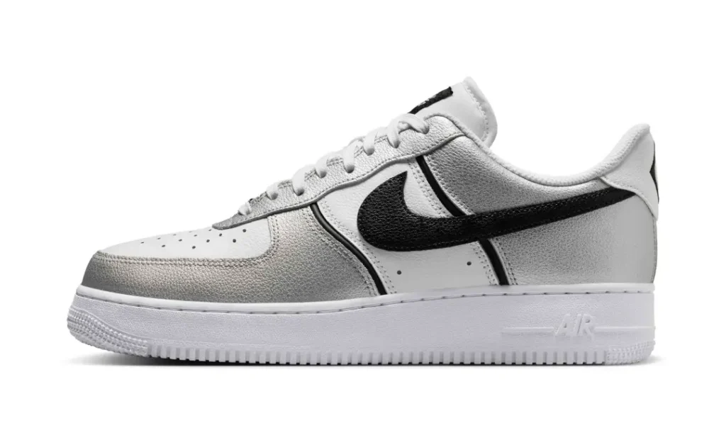 Side profile of the Nike Air Force 1 Low featuring metallic silver overlays, a black leather Swoosh, white tumbled leather underlays, and a classic white Air sole unit