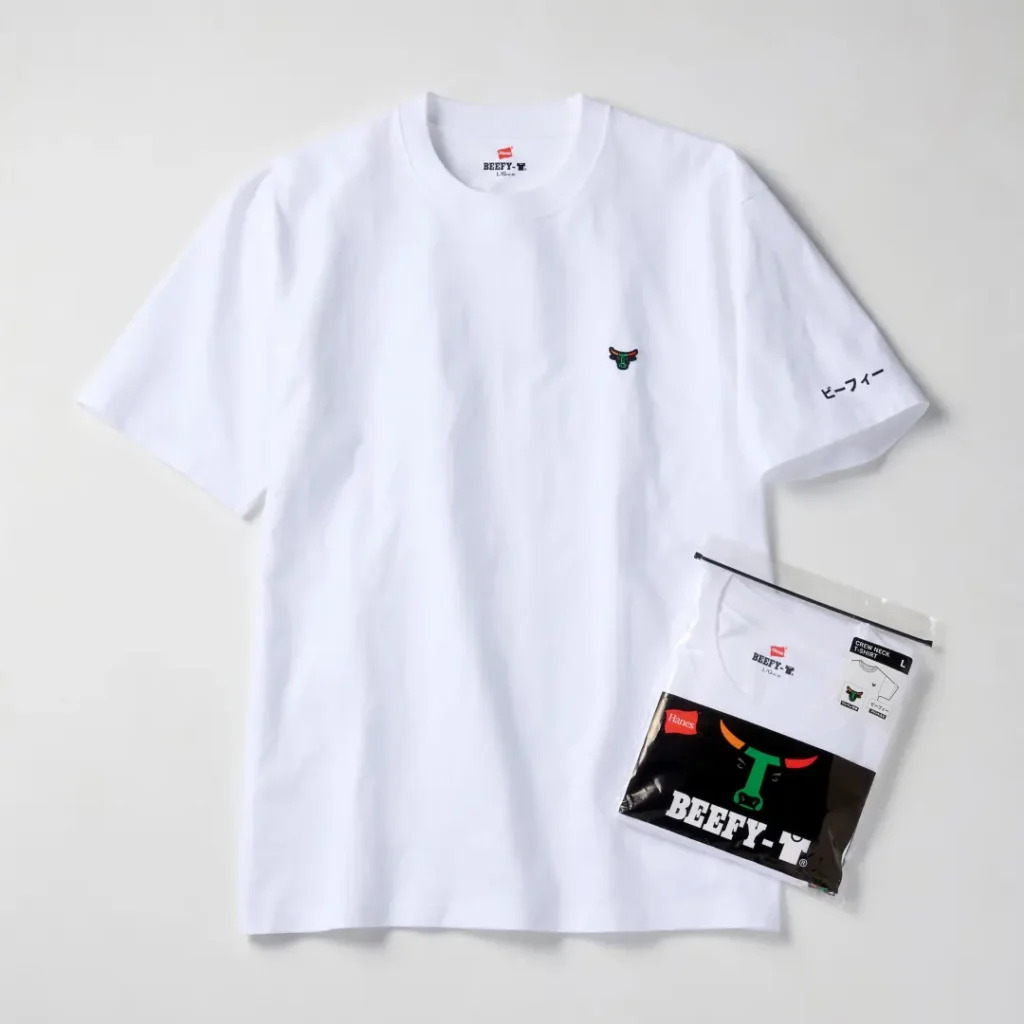White Hanes BEEFY crew-neck T-shirt styled beside its branded retail packaging. The design combines a minimalist silhouette with a small embroidered bull-head logo and Japanese sleeve print