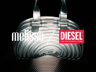 Transparent Melissa × Diesel handbag with sculpted ripple contours, photographed against a black background with metallic reflections highlighting its futuristic shell-like shape