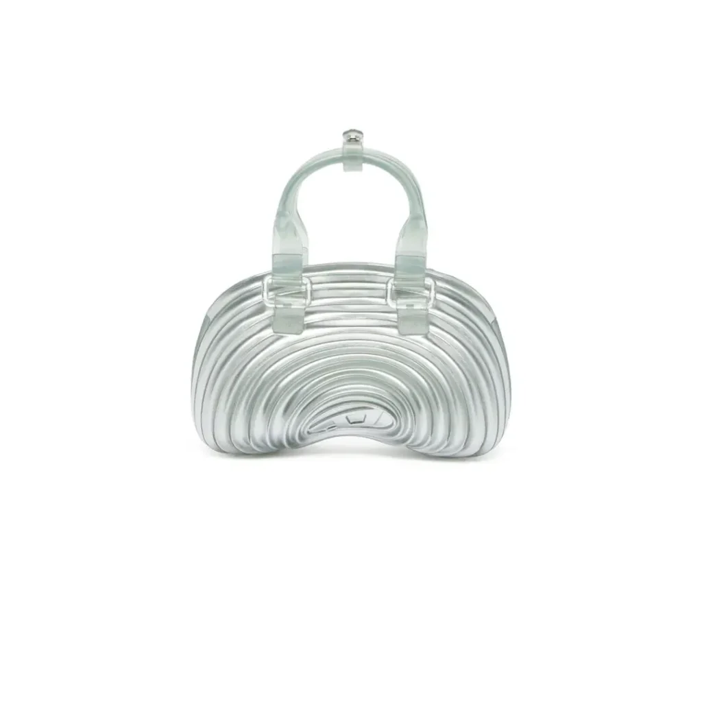 Front-facing product image of a translucent Melissa × Diesel handbag featuring curved molded ridges, transparent handles, and a futuristic jelly-like construction
