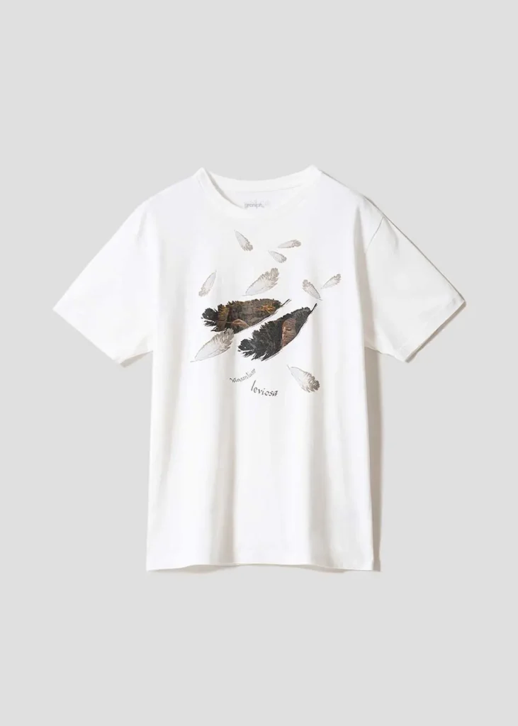 White oversized T-shirt featuring floating feather illustrations and a magical levitation-inspired graphic referencing the Wingardium Leviosa spell