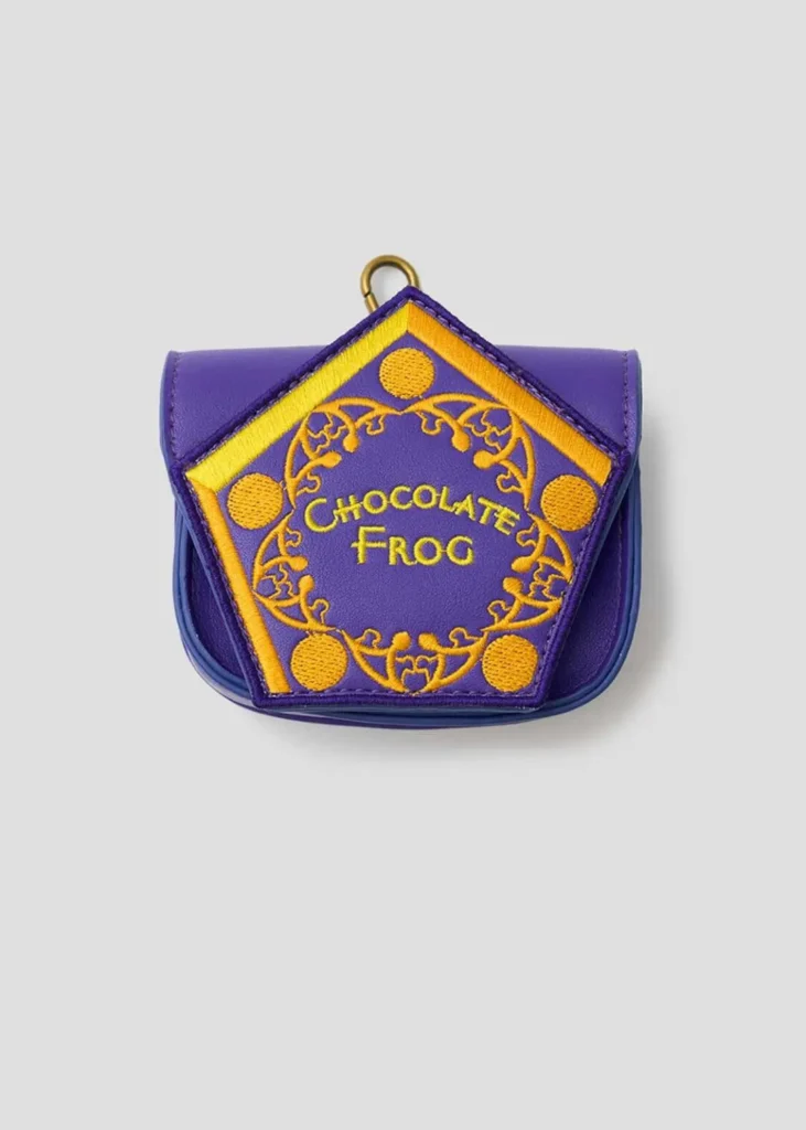 Purple Chocolate Frog-themed mini pouch featuring gold embroidered lettering and decorative wizarding-world-inspired details, designed to resemble the iconic confectionery packaging