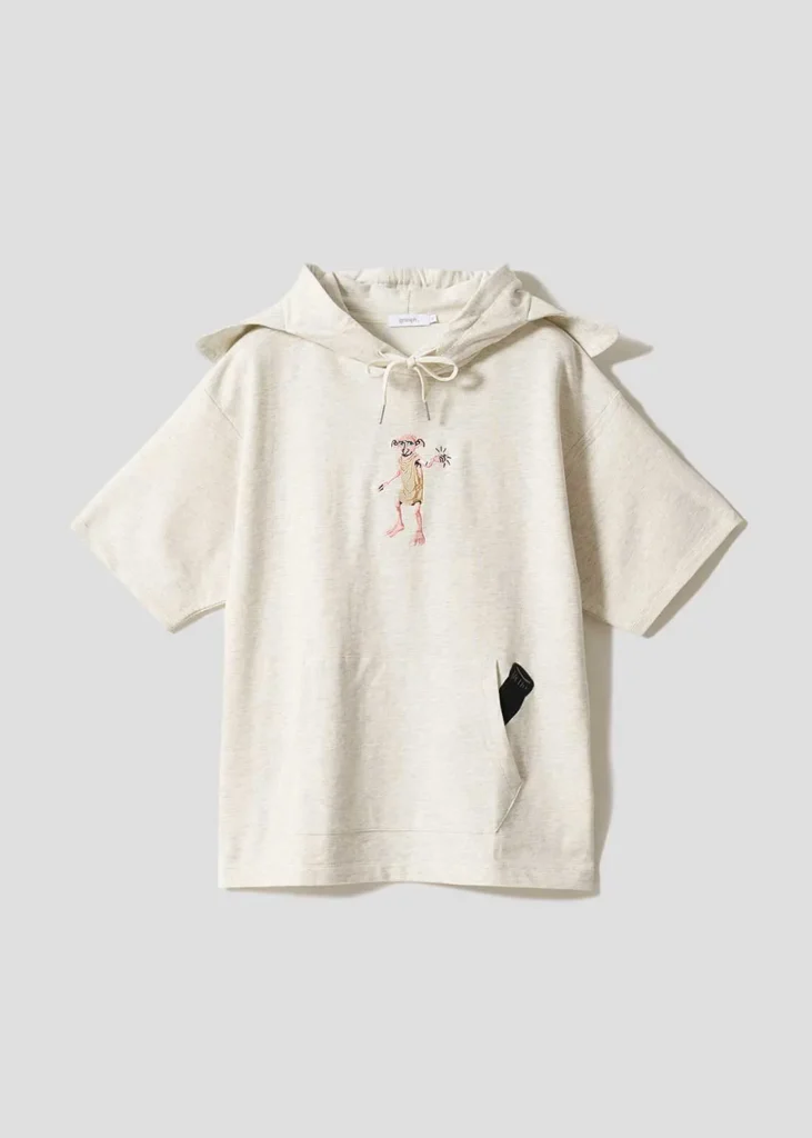 Cream-colored short-sleeve hoodie with an oversized fit, featuring a small embroidered Dobby graphic at the center chest, drawstring hood, and front kangaroo pocket