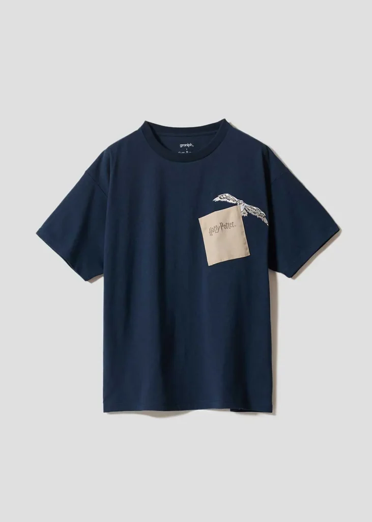 Navy oversized T-shirt featuring a flying Hogwarts acceptance letter graphic emerging from the chest pocket area, accompanied by owl wing