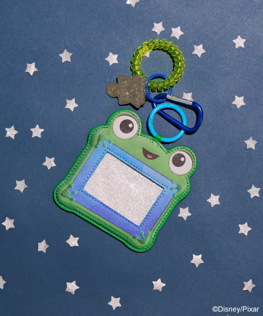 Little Green Alien-inspired ID holder accessory with bright green character face design, colorful hardware, and Toy Story-themed keyring attach