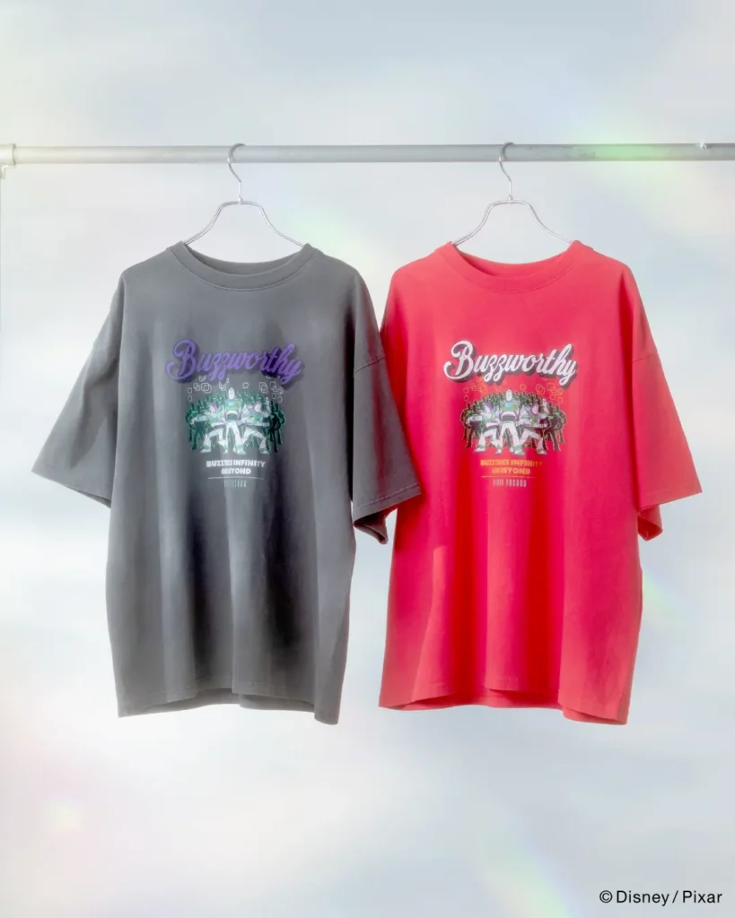 Buzz Lightyear-inspired graphic T-shirts in washed charcoal and vibrant pink featuring futuristic artwork and “Buzzworthy” typography
