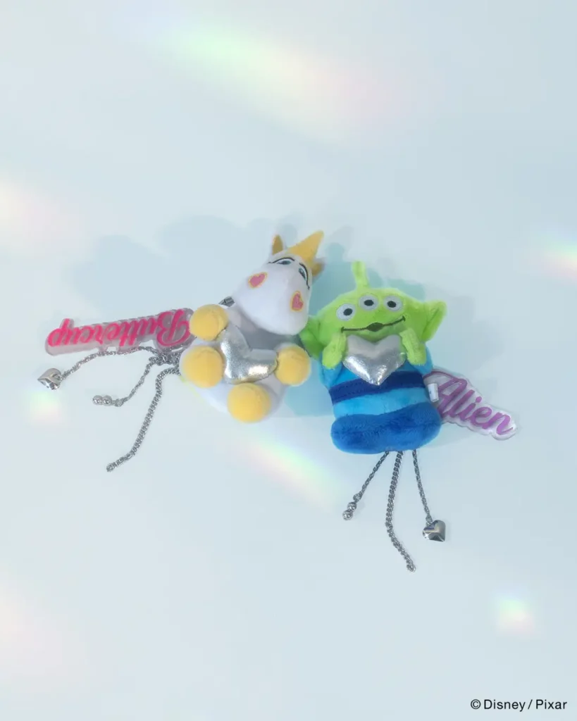Character face pouch charms featuring Woody, Jessie, and Buzz Lightyear with metallic western-themed chain accents and collectible accessory detail