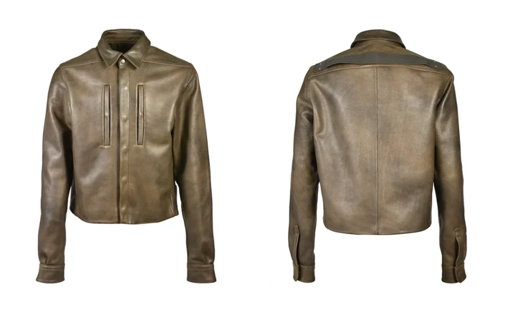 Front and back product views of the NUBIAN × Rick Owens cropped leather jacket on a white background, showcasing the minimalist silhouette and rear shoulder strap detail