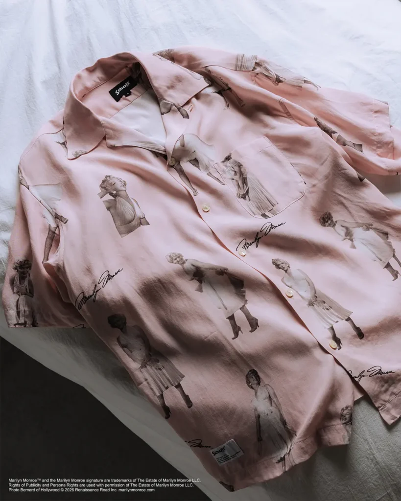 Light pink short-sleeve camp-collar shirt featuring an all-over print of vintage Marilyn Monroe portraits and signature graphics, styled with a relaxed silhouette and chest pocket