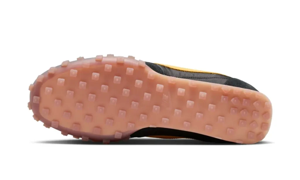 Bottom view of the shoe showcasing Nike’s signature waffle traction pattern in a translucent pink-tinted rubber outsole
