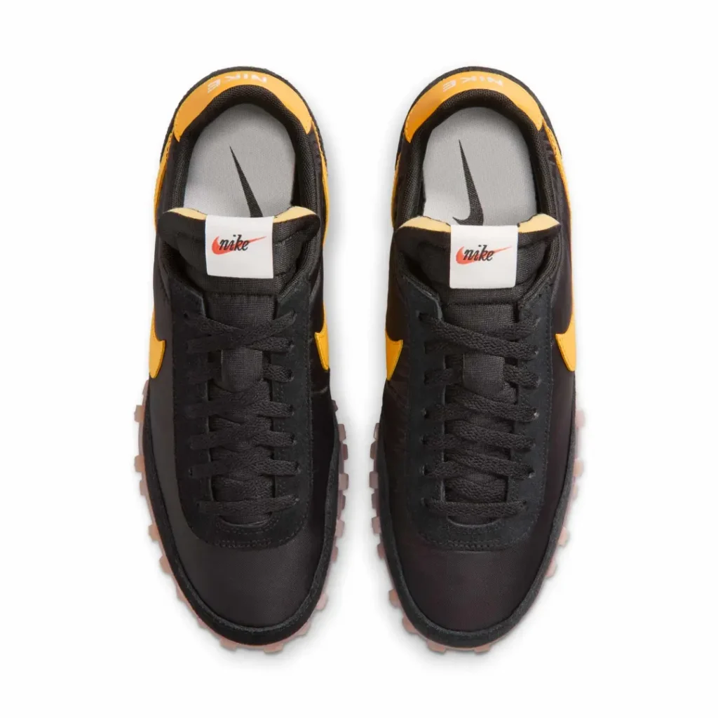 Top-down look at the Nike retro sneaker featuring black flat laces, nylon tongue construction, and contrasting yellow heel accent