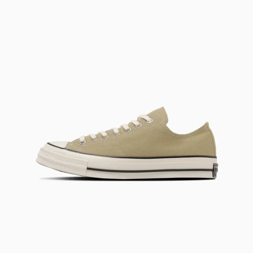 Side profile of the beige Converse Chuck Taylor All Star low-top shoe highlighting neutral canvas construction, contrast stitching, cream laces, and timeless low-cut style