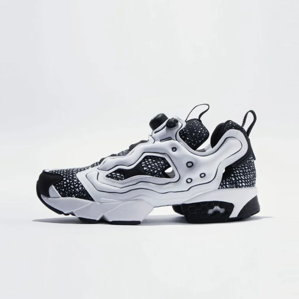 Medial side view of the collision Reebok Instapump Fury, revealing the flowing cage design, monochrome detailing, and distinctive Instapump construction