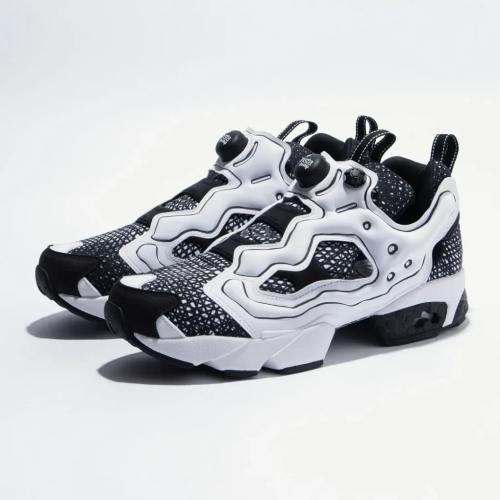 Angled pair shot of the Reebok Instapump Fury collection edition, emphasizing the contrast between the white overlays and black patterned base