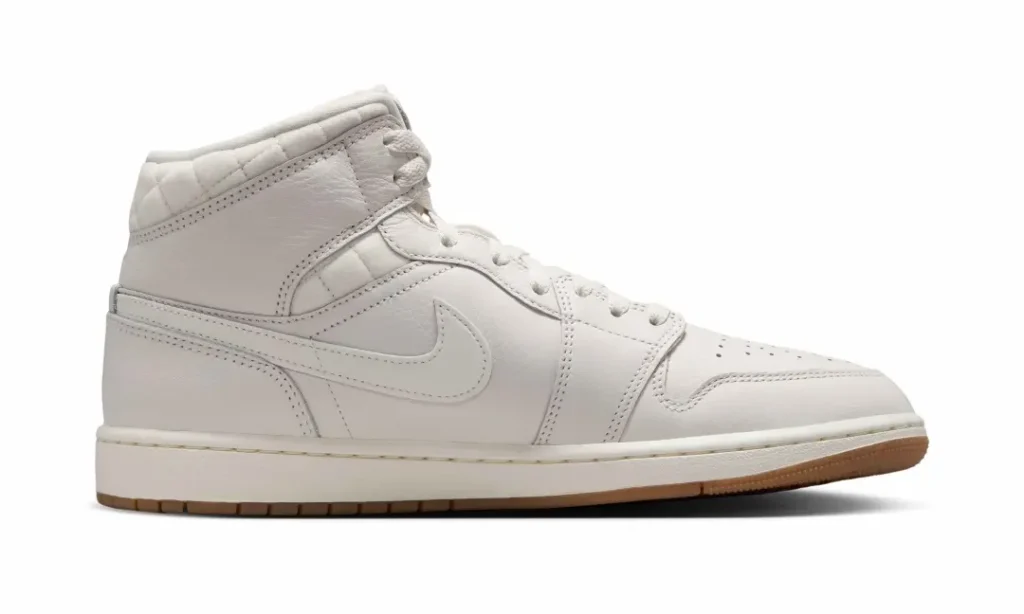 Medial side view of the Air Jordan 1 Mid Premium showcasing sail leather panels, tonal stitching, quilted collar accents, and a clean monochromatic aesthetic
