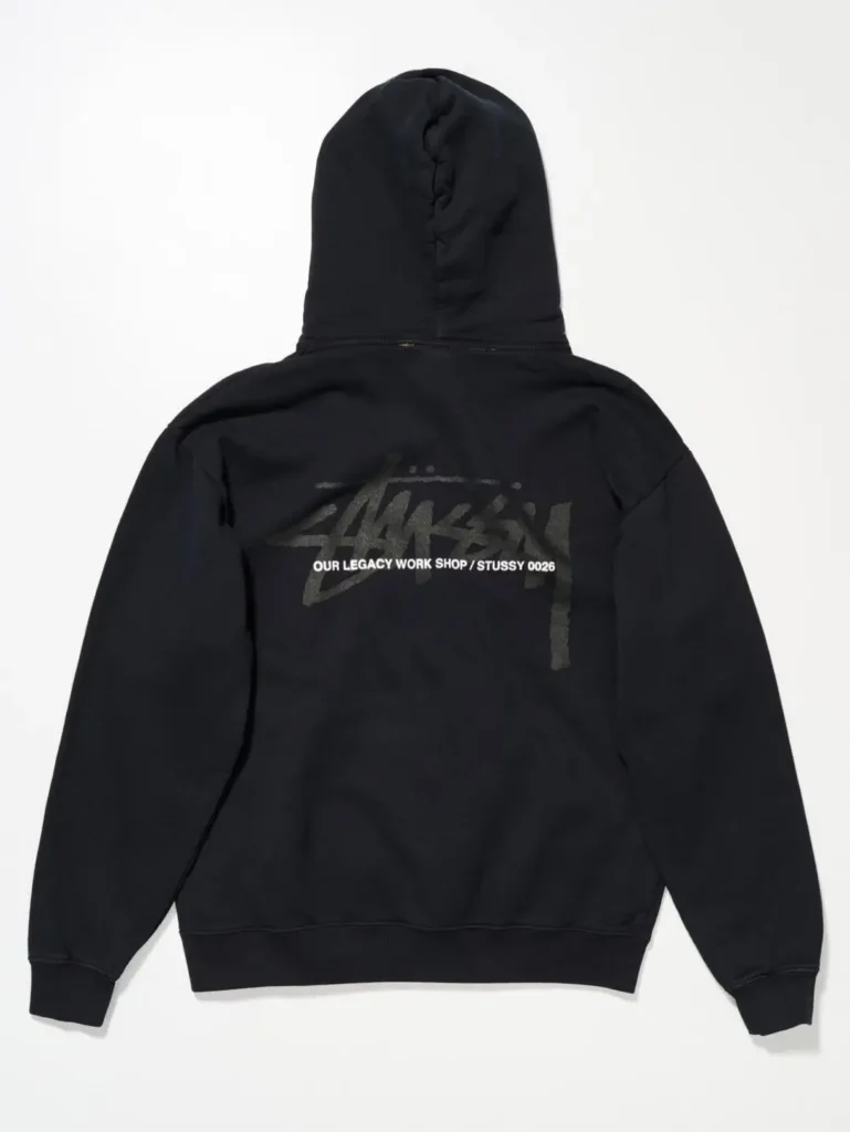 Black hoodie with oversized tonal Stüssy logo and collaborative Our Legacy Workshop branding printed across the back