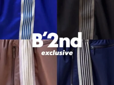 Collage showcasing multiple colorways of Needles B'2nd exclusive track shorts. Close-up fabric details highlight signature striped side tape, zip pockets, and the embroidered butterfly logo in royal blue, black, navy, and dusty pink