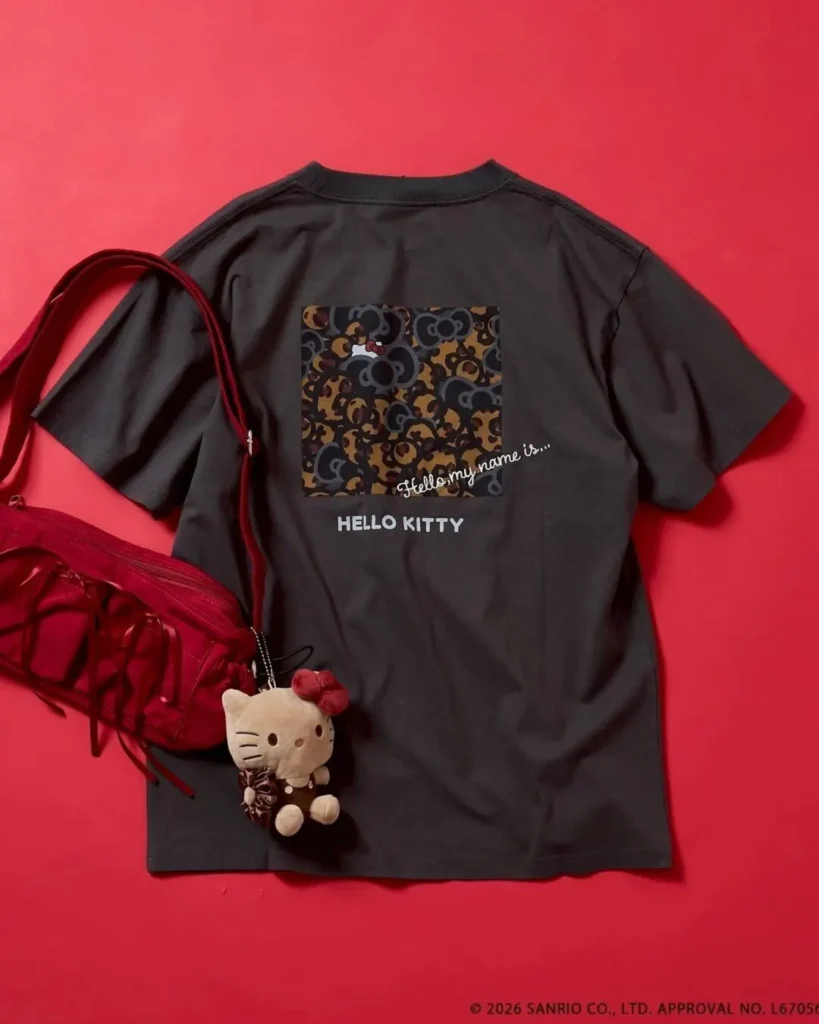 Black Hello Kitty graphic T-shirt styled with a matching plush keychain and red transparent shoulder bag, showcasing the large back print design