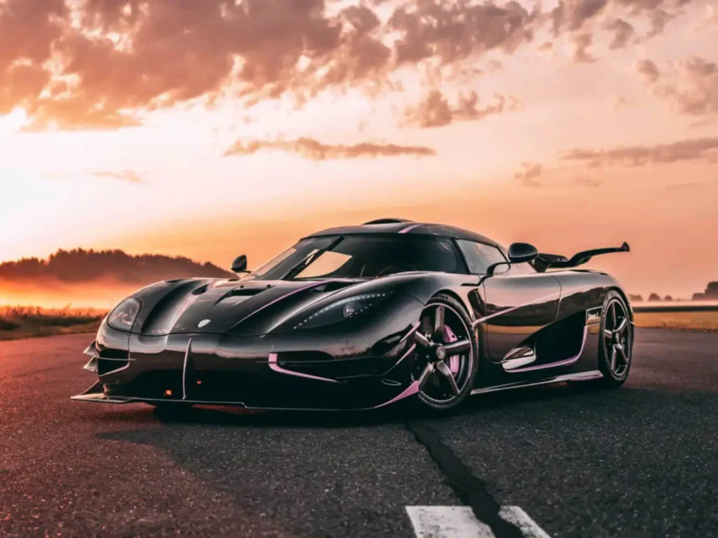 Front three-quarter beauty shot of the Koenigsegg One:1 on an open runway at golden hour, highlighting its low-slung stance, carbon-fiber body, and record-setting hypercar pedigree