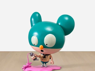 Designer vinyl figure with a teal oversized head, wide eyes, and a spray paint can, standing on a pink paint puddle against a minimalist backdrop