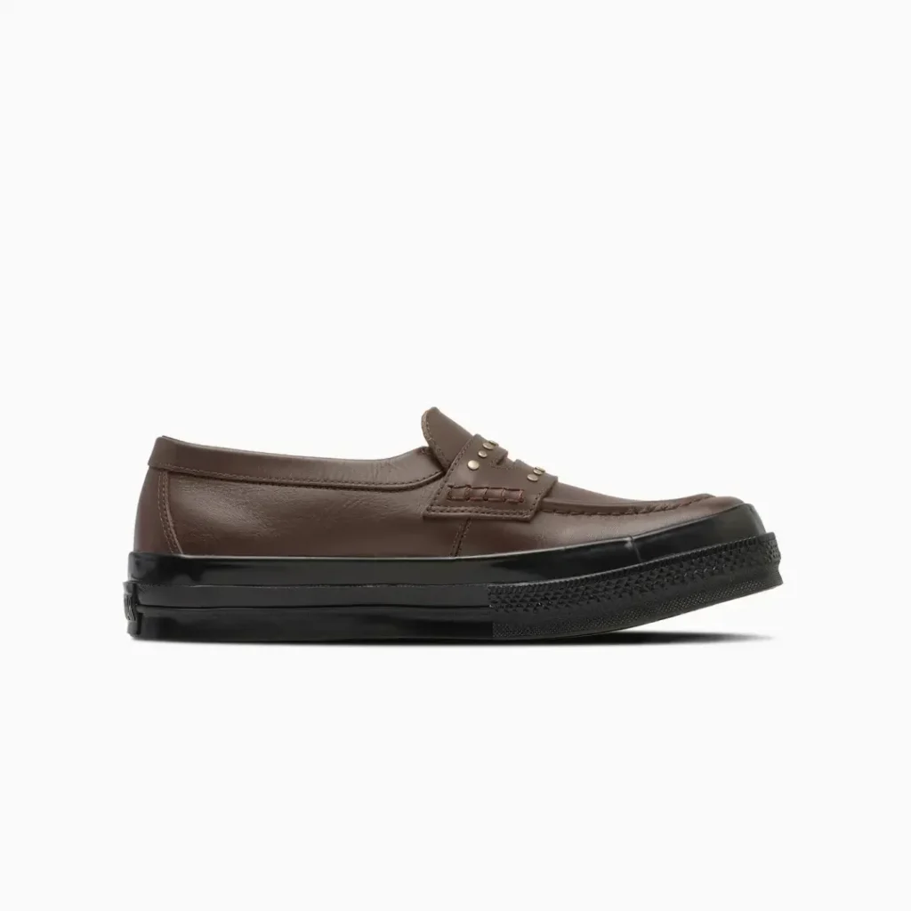 Opposite lateral side of the brown Converse penny loafer featuring a clean leather upper, low-profile silhouette, and black rubber sole